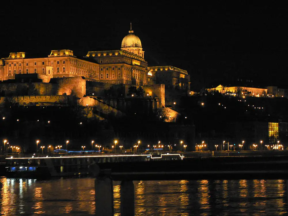 A kivilágított Budavári Palota éjjel, előtte a Duna